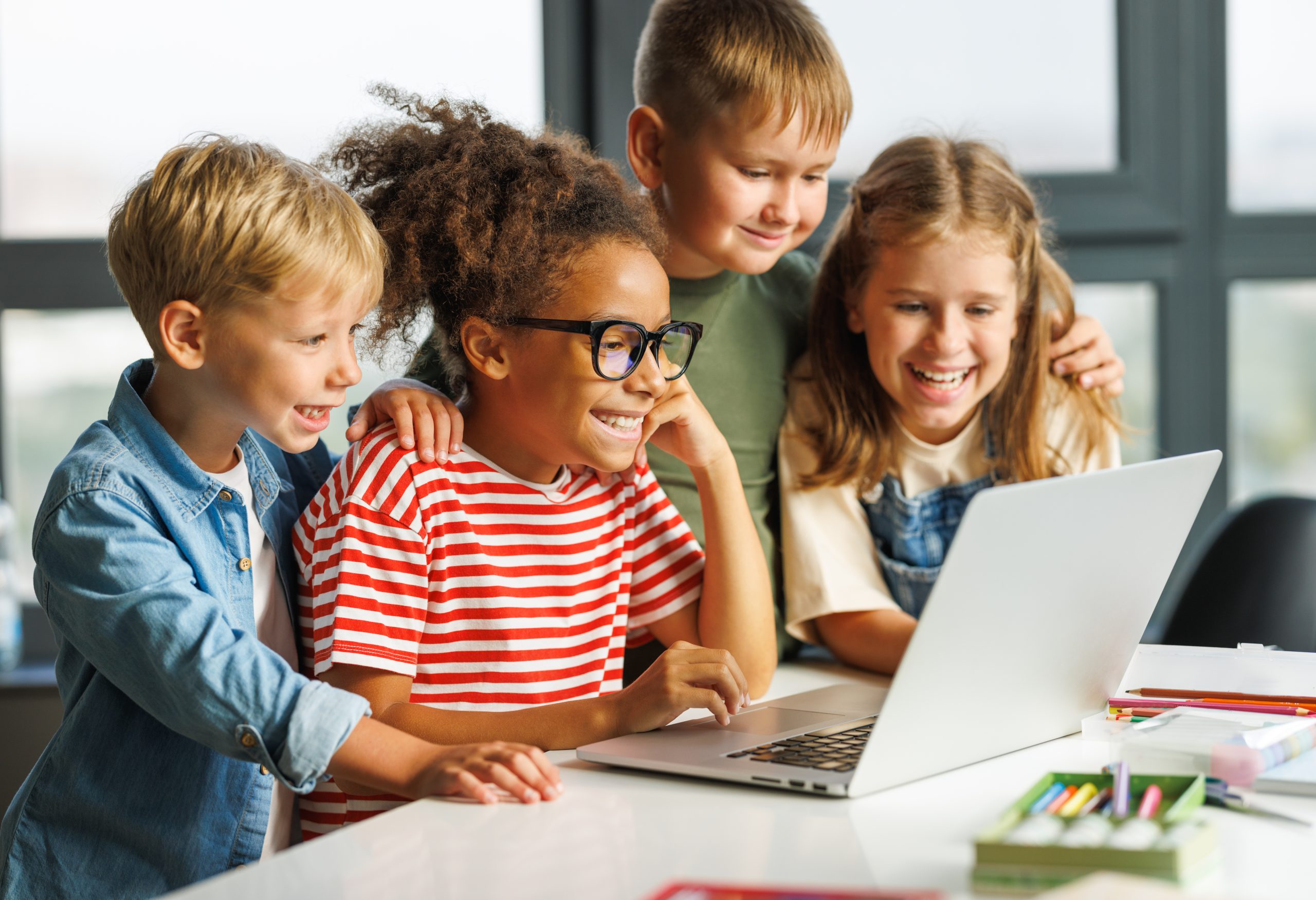 Grupo de niños felices viendo el portatil